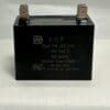 A black rectangular ADP350F206J 20 uF 350 VAC capacitor (model 195-202-0350) with two metal terminals on top, placed on a light-colored surface. The capacitor displays its specifications and certifications on the label.
