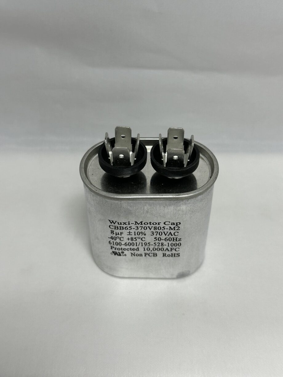 A Scotsman 18-3701-01 Run Capacitor (CBB65-370V805-M2, 8 uF, 370 VAC), featuring a silver cylindrical body with two black terminals and exposed metal prongs labeled with technical specifications, sits against a plain white background.