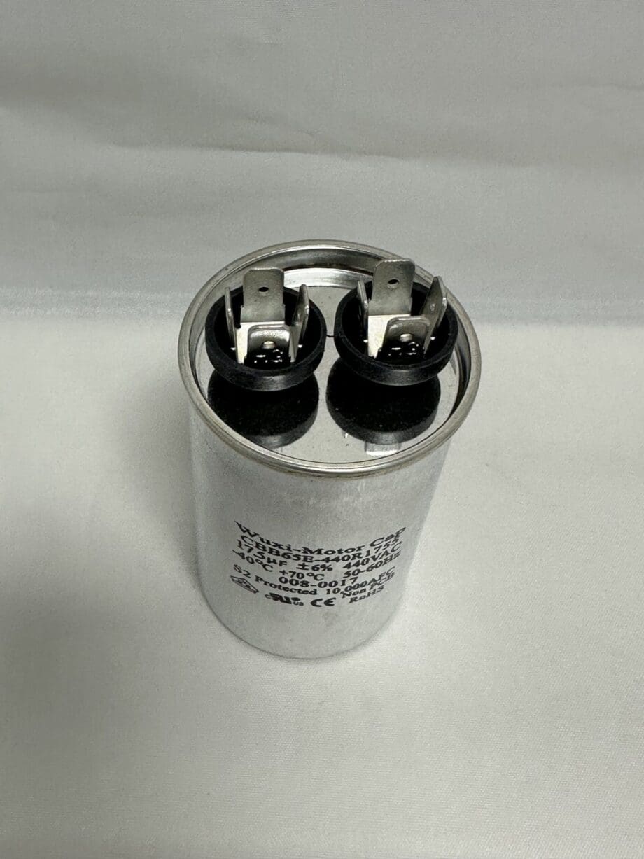 A Scotsman 18-1902-65 Run Capacitor CBB65-440R1755 (17.5 uF, 440 VAC, 12236) is shown as a silver cylindrical electrical capacitor with two black terminal connectors on top, photographed against a plain white background.